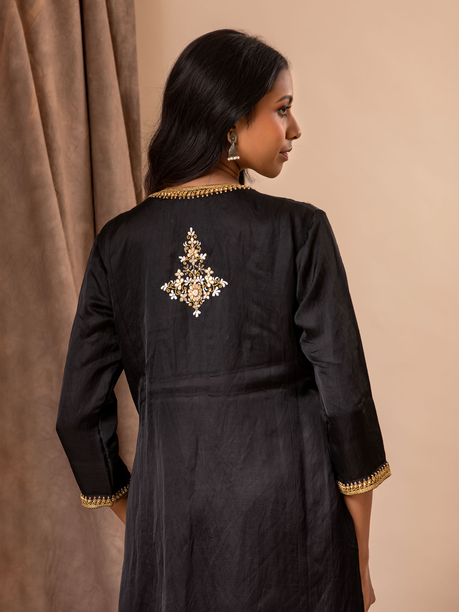 Black linen satin straight-cut top with Gota Patti and threadwork bhutis, paired with rayon pants.