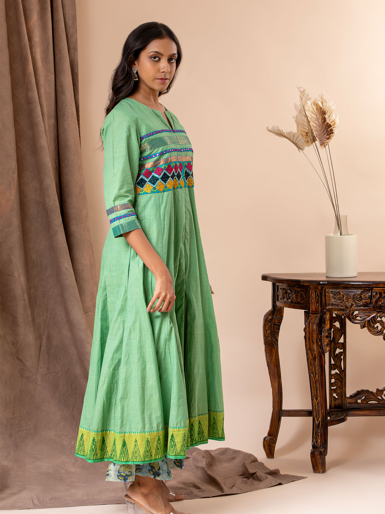 Light green kali top with Kutch work and mirror work, paired with batik printed pants