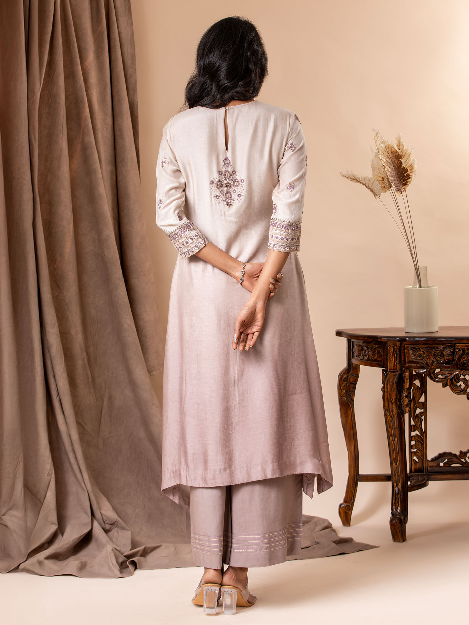 Muslin top in shades of mauve with all over thread and mirror handwork, paired with pants.